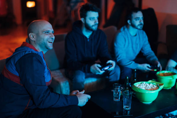 istock Man celebrating his win at video game, while his friend scan't accept that they loss this match 1307610011