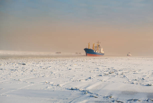 冬の船積み。凍った氷の海の大きな貨物船 - snow winter coastline sunrise ストックフォトと画像