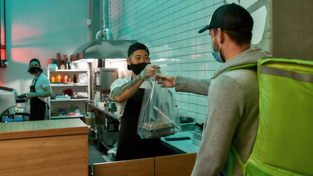 istock Delivery man picking up an order at a restaurant 1307612191