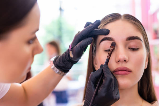 istock Young woman correcting eyebrows form in salon by artist 1307612437