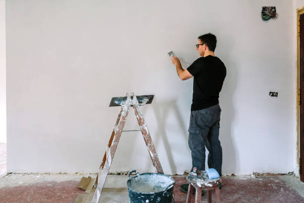 istock Bricklayer repairing the wall with a spatula 1307614066
