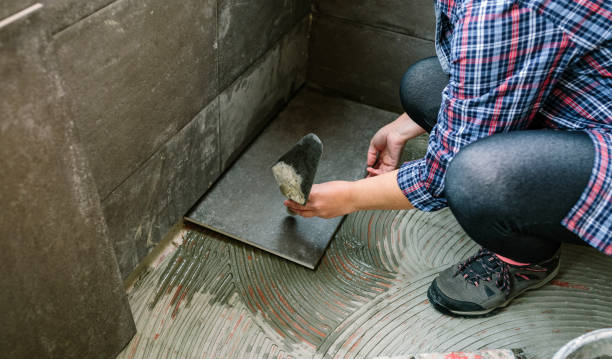 istock Female manual worker laying a new tile floor 1307614067