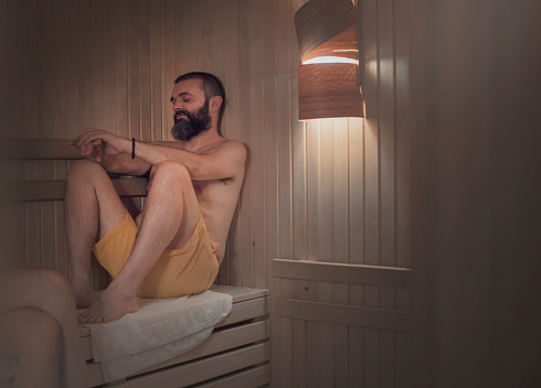 Young man relaxing in sauna
