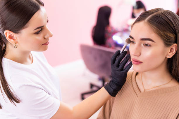 istock Eyebrow tinting. Close up master applying brow tint with a brush. Cosmetic procedures, eyebrow permanent makeup 1307615639