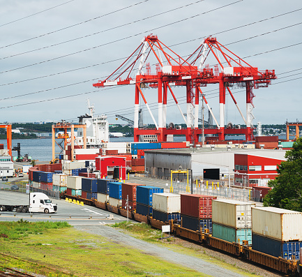 A freight train leaves port with a long line of cargo.