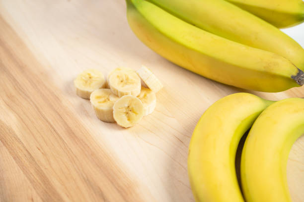 istock Bananas on wooden cutting board 1307617649