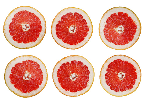 Grapefruit slices in a row, isolated on white background.
