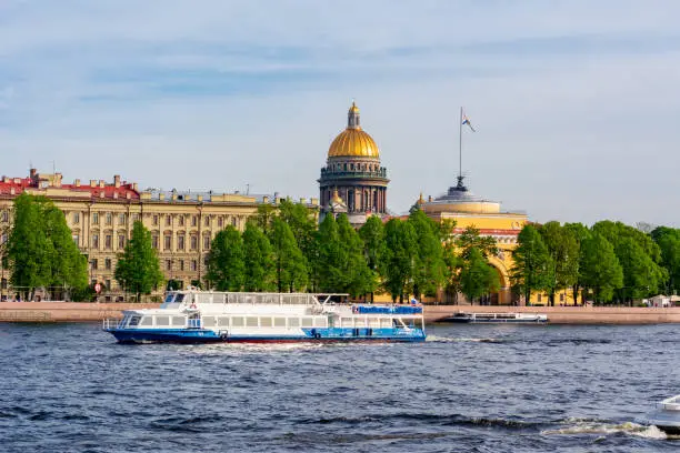 St. Isaac's Cathedral dome and cruise boat along Neva river, Saint Petersburg, Russia