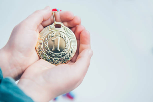 Hand holding gold medal. stock photo