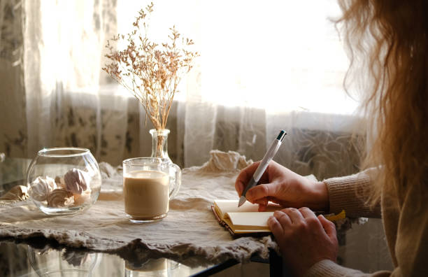 istock Cropped image of woman drinking coffee and reading a book 1307623567