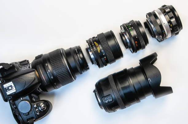 istock camera and photo lenses on white background. Concept of interchangeable lenses and optics. Flat lay, top view. 1307624754