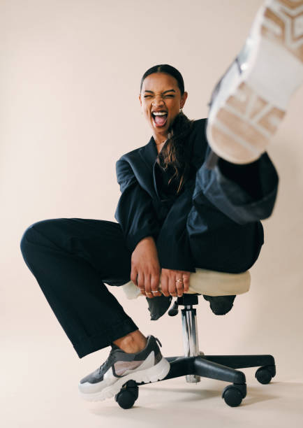 Too glam to give a damn Studio portrait of a beautiful young woman screaming while sitting on a chair against a brown background legs apart stock pictures, royalty-free photos & images