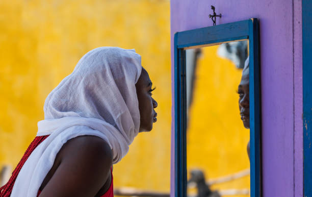 afrika frau mit blick auf spiegel - veil women black beauty stock-fotos und bilder