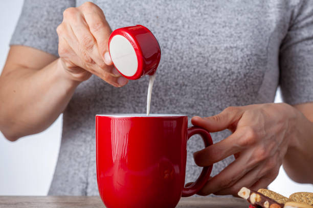 ホットドリンクのカップにクリーマーを追加 - hot drink tea black tea red ストックフォトと画像
