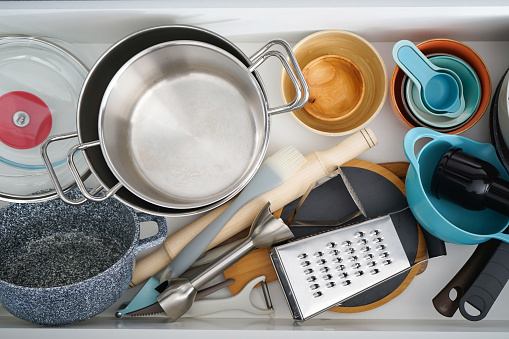 Open drawer with different utensils in kitchen, flat lay.