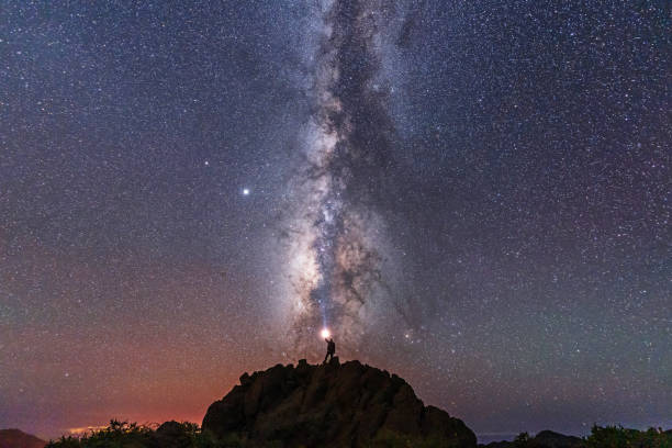 A young man with a flashlight below the beautiful lactea way of the Caldera de Taburiente near the Roque de los Muchahos on the island of La Palma, Canary Islands. Spain, astrophotography stock photo