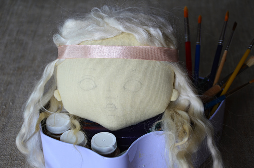 The manufacture of textiles toys. The doll's head, prepared for face coloring with paints.