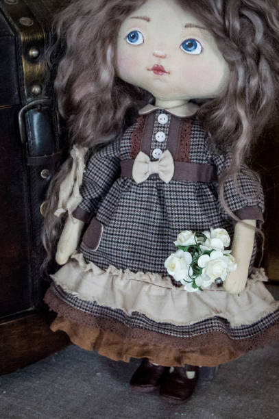 istock Textile interior doll stands with a bouquet of flowers. Handmade work. 1307634455