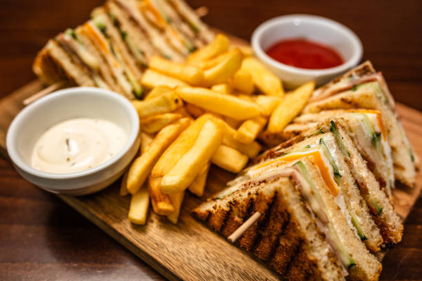 Ham (or turkey / or chicken) and cheese classical style decker sandwich, with tomato, lettuce and mayonnaise. Club sandwich. Studio photography. High angle view. Isolated.