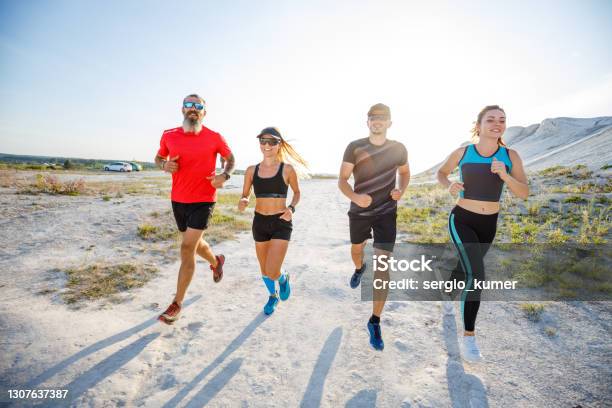 Four Friends Run Together On Trail Running Stock Photo - Download Image Now - 20-29 Years, 30-39 Years, Active Lifestyle