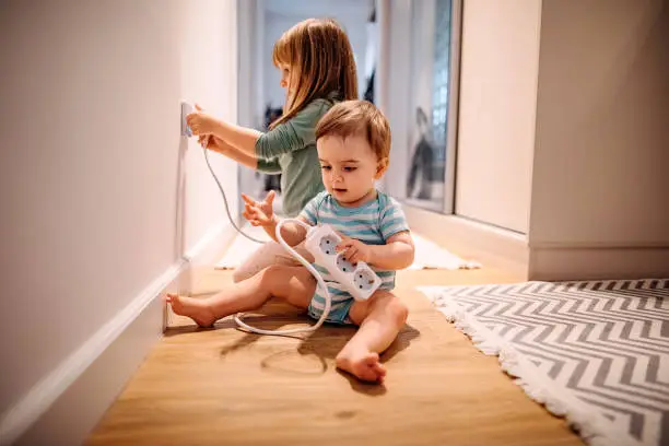 Brother and sister playing at home with electricity