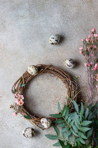istock Spring composition with braided wreath of twigs with flowers and quail eggs. Easter wreath or nest from rattan. DIY creativity. Top view. 1307639959
