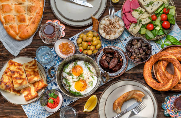 istock Delicious rich Traditional Turkish breakfast include tomatoes, cucumbers, cheese, butter, eggs, honey, bread, bagels, olives and tea cups. Ramadan Suhoor aka Sahur. 1307642290