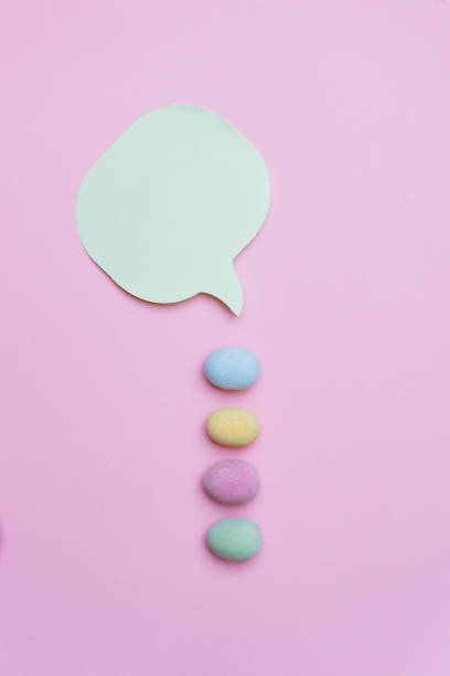 istock Easter eggs with speech bubble on pink background. Copy space background.
