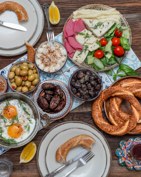 istock Delicious rich Traditional Turkish breakfast include tomatoes, cucumbers, cheese, butter, eggs, honey, bread, bagels, olives and tea cups. Ramadan Suhoor aka Sahur. 1307642327