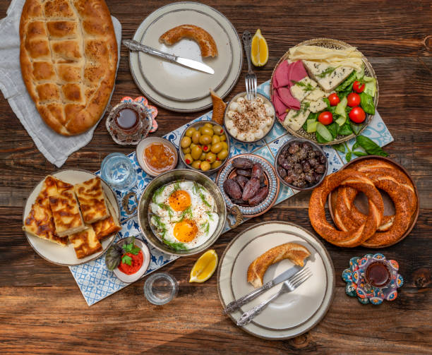 istock Delicious rich Traditional Turkish breakfast include tomatoes, cucumbers, cheese, butter, eggs, honey, bread, bagels, olives and tea cups. Ramadan Suhoor aka Sahur. 1307642357