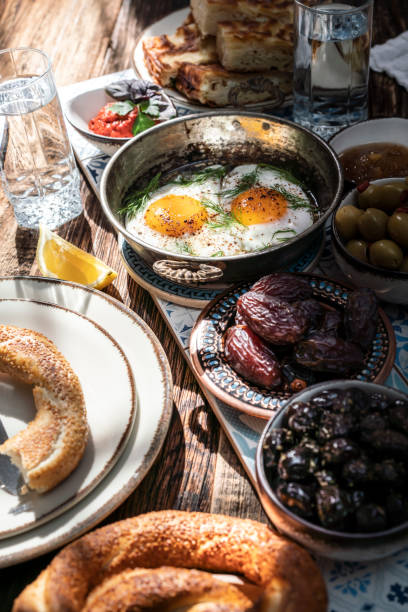 istock Delicious rich Traditional Turkish breakfast include tomatoes, cucumbers, cheese, butter, eggs, honey, bread, bagels, olives and tea cups. Ramadan Suhoor aka Sahur. 1307642585