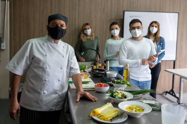 istock Chef with a group of culinary students wearing facemasks in class 1307643448