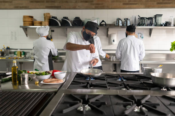 istock Chef wearing a facemask while working in a commercial kitchen during the pandemic 1307643460