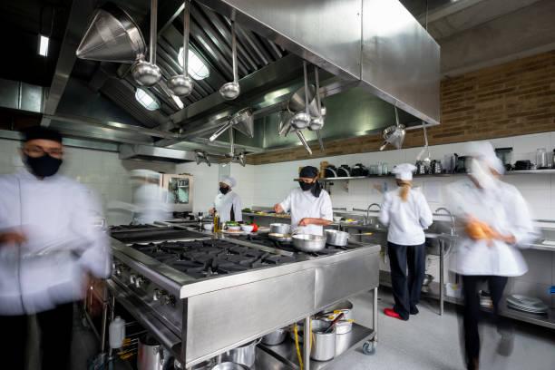 kock som arbetar i ett kök med ansiktsmask under pandemin - suddig rörelseeffekt - storkök bildbanksfoton och bilder