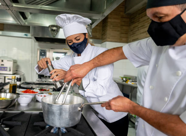 istock Chefs wearing facemasks while cooking at a restaurant during the pandemic 1307643485