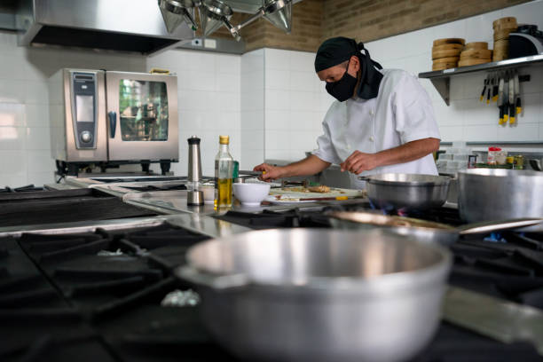 istock Cook wearing a facemask while cooking in a kitchen during the pandemic 1307643501