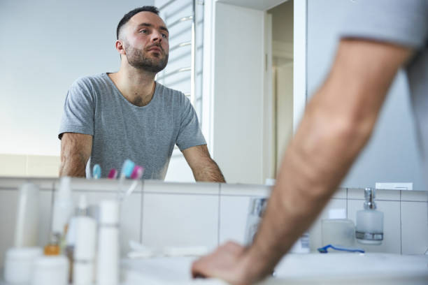 istock Attractive young man looking in the mirror in bathroom 1307643812