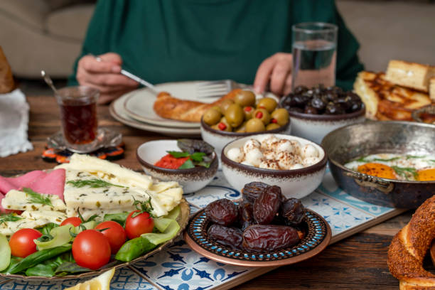 istock Delicious rich Traditional Turkish breakfast include tomatoes, cucumbers, cheese, butter, eggs, honey, bread, bagels, olives and tea cups. Ramadan Suhoor aka Sahur. 1307644411