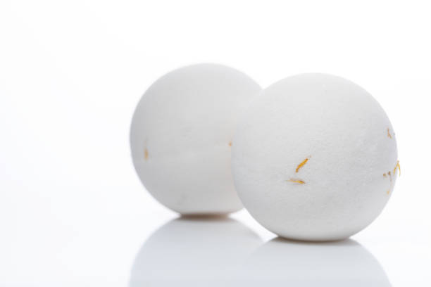 bath bombs white with flowers on a light background with reflection, the concept of mineral cosmetics for a shower