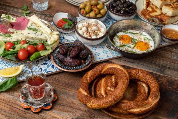 istock Delicious rich Traditional Turkish breakfast include tomatoes, cucumbers, cheese, butter, eggs, honey, bread, bagels, olives and tea cups. Ramadan Suhoor aka Sahur. 1307645488