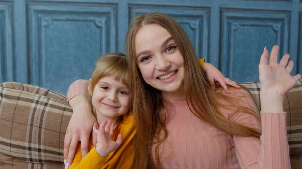 istock Child kid daughter with mother, embracing, waving hands to camera doing hello welcome or bye gesture 1307646883