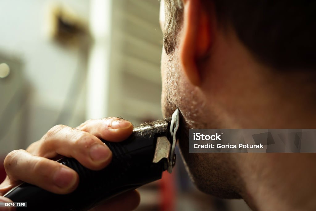 Man using electric razor for beard Man using electric razor for shaving his beard Electric Razor Stock Photo