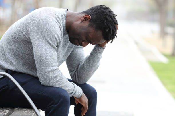 istock Sad black man is complaining alone in a park 1307649093