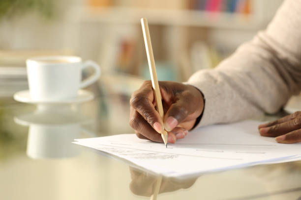 istock Black man hand drawing in a paper sheet on a desk 1307649197