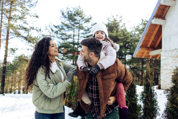 szczęśliwa rodzina bawiąc się podczas ferii zimowych - kurort narciarski zdjęcia i obrazy z banku zdjęć