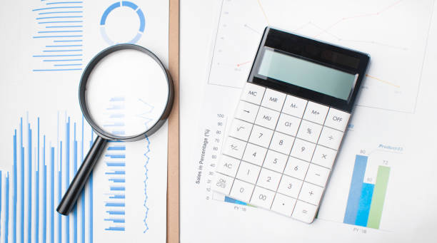 istock pen, magnifying glass and the working paper with a diagram 1307650987