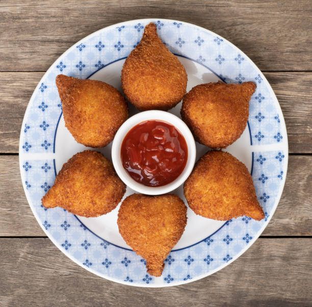 Typical brazilian snack coxinha on a plate with ketchup Typical brazilian snack coxinha on a plate with ketchup. coxinha stock pictures, royalty-free photos & images