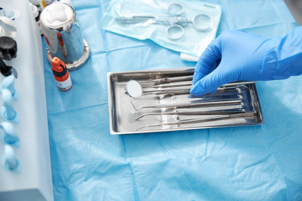 istock Hand picking dental tool from stainless steel tray 1307652113