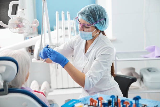 istock Female dental surgeon inserting a bur in handpiece 1307652139