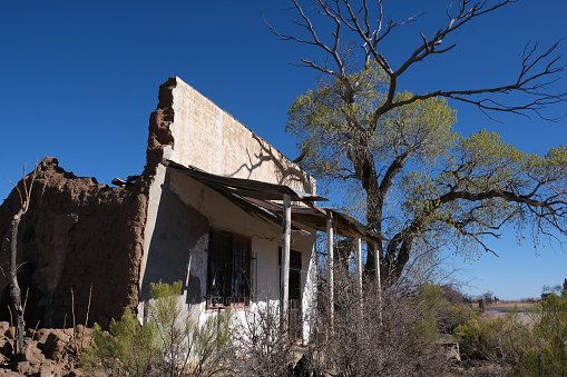 Abandoned falling down building in Gleeson AZ.  Bricks, rubble, decaying and about to fall building against blue sky.